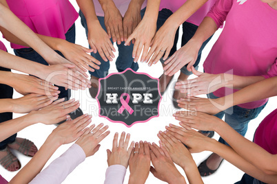 Composite image of hands joined in circle wearing pink for breas