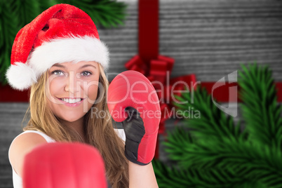 Composite image of festive blonde punching with boxing gloves