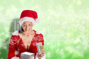 Composite image of smiling woman opening christmas present