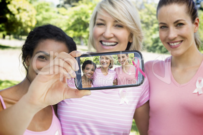 Composite image of hand holding smartphone showing