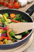 Essen vegetarisch zubereiten Gemüse in der Pfanne mit Pfannenwe