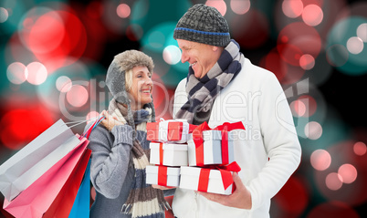 Composite image of festive mature couple holding christmas gifts