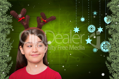 Composite image of festive little girl wearing antlers