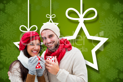 Composite image of winter couple holding mugs