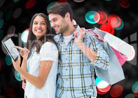 Composite image of happy couple with shopping bags