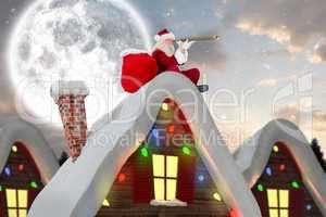 Composite image of santa sitting on roof of cottage