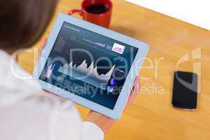 Composite image of businesswoman using tablet at desk