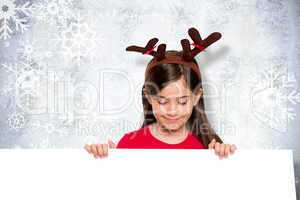 Composite image of festive little girl showing card