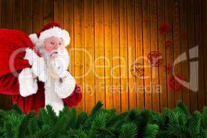 Composite image of santa claus carrying sack