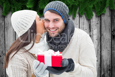 Composite image of winter couple holding gift