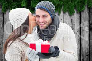 Composite image of winter couple holding gift