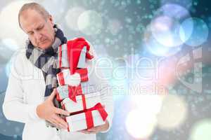 Composite image of festive man holding christmas gifts