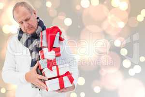 Composite image of festive man holding christmas gifts