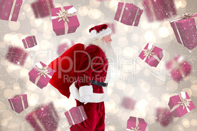 Composite image of santa claus carrying sack