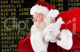 Composite image of santa claus carrying sack