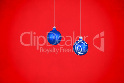 Composite image of two hanging blue bauble decorations