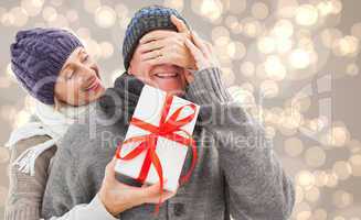 Composite image of mature woman surprising partner with gift