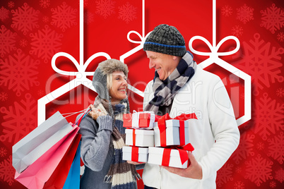 Composite image of festive mature couple holding christmas gifts