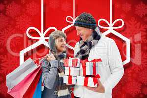 Composite image of festive mature couple holding christmas gifts