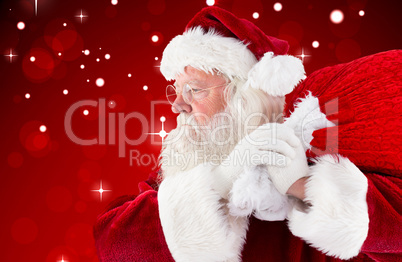 Composite image of santa claus carrying sack