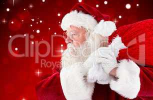 Composite image of santa claus carrying sack