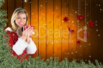 Composite image of pretty santa girl holding mug