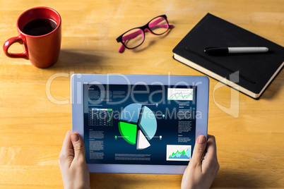 Composite image of businesswoman using tablet at desk