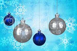 Composite image of blue and silver christmas baubles