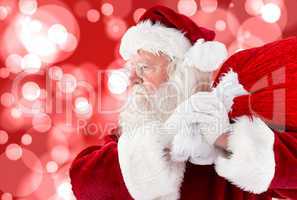 Composite image of santa claus carrying sack