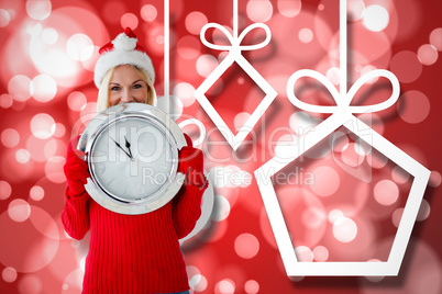 Composite image of happy festive blonde with clock