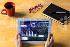 Composite image of businesswoman using tablet at desk