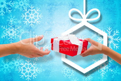 Composite image of couple passing a wrapped gift