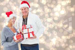 Composite image of festive mature couple holding christmas gifts