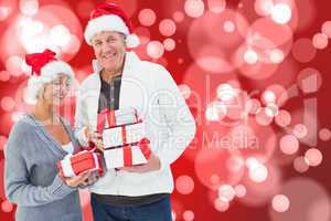 Composite image of festive mature couple holding christmas gifts