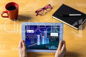 Composite image of businesswoman using tablet at desk