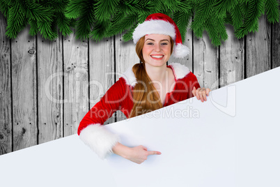 Composite image of pretty girl in santa costume showing card