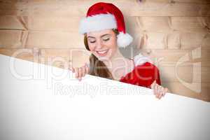 Composite image of pretty girl in santa costume showing card