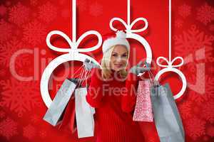 Composite image of happy festive blonde with shopping bags