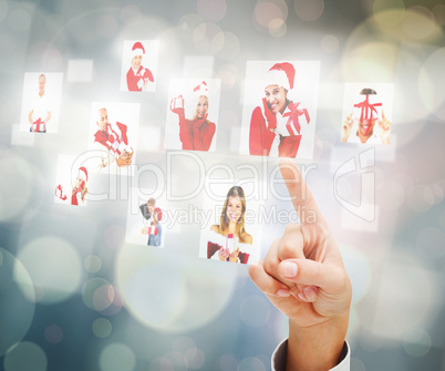 Composite image of hand pointing to christmas people collage