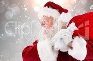 Composite image of santa claus carrying sack