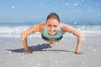 Fit woman in plank position on the beach