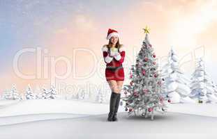 Composite image of pretty girl in santa costume holding gift box