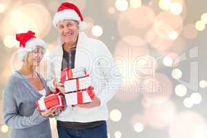 Composite image of festive mature couple holding christmas gifts