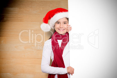 Composite image of festive little girl showing card