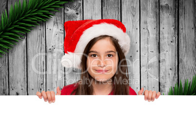 Composite image of festive little girl showing card