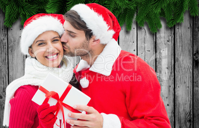 Composite image of festive young couple holding gift