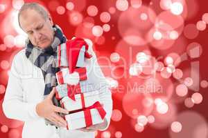 Composite image of festive man holding christmas gifts