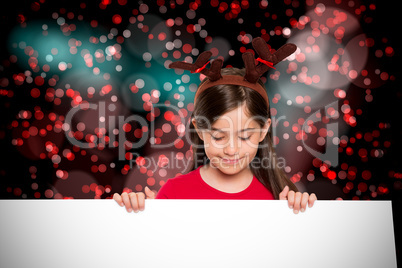 Composite image of festive little girl showing card