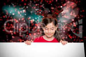 Composite image of festive little girl showing card