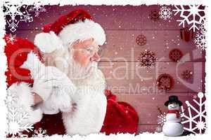 Composite image of santa claus carrying sack